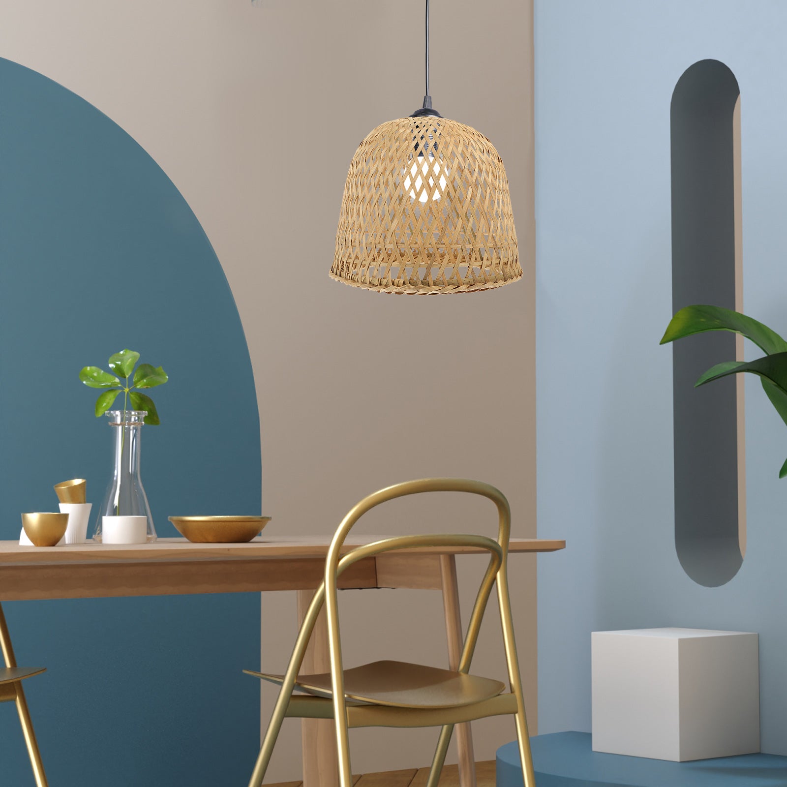 Pièce avec le mur du fond beige et bleu, le mur de droite bleu clair avec une ouverture  longiligne arrondit en haut et en bas avec un carré blanc juste en dessous. On voit une table en bois, avec des bols et une assiette blanc et dorés, un vase avec une feuille, une chaise dorée de dos. Haut dessus un abat-jour en rotin tressé avec une ampoule allumée.