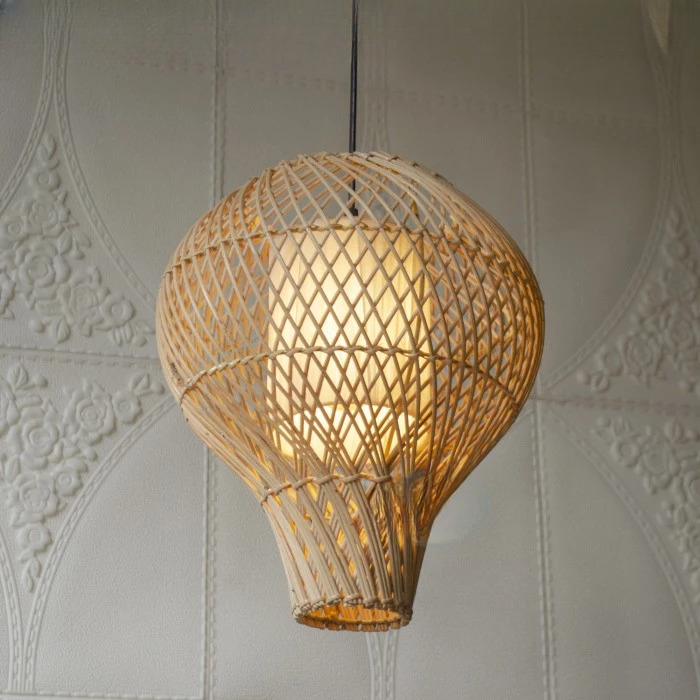 Lustre salon rotin décoratif en forme de montgolfière, présentée allumée