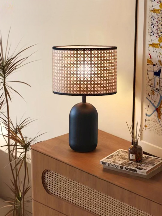 Lampe de chevet rotin rétro avec base noire présentée présentée sur un meuble en bois